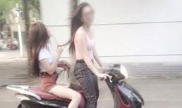 Thiếu nữ đầu trần đứng lái xe máy
