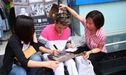 Đàm Vĩnh Hưng ngồi bệt dưới thềm mải miết ký tặng fans