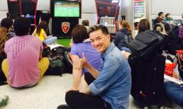Đàm Vĩnh Hưng ngồi bệt xem bóng đá ở sân bay