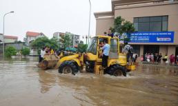 Người dân Thủ đô cưỡi máy xúc vượt ngập lụt giữa đường phố