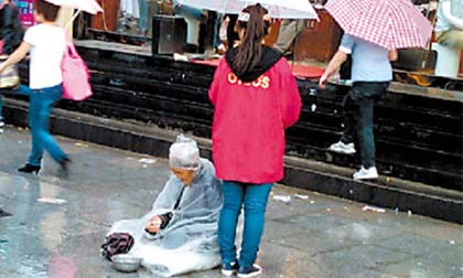 Chịu mất việc để che mưa cho bà lão ăn xin