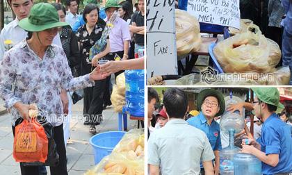 Người dân ăn vội miếng bánh, hớp nước trong lúc đợi viếng Đại tướng