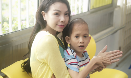 Trà Ngọc Hằng âu yếm cưng nựng trẻ em nhiễm chất độc da cam