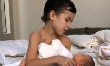 Cậu nhóc bế, hát ru em bé sơ sinh khéo như người lớn