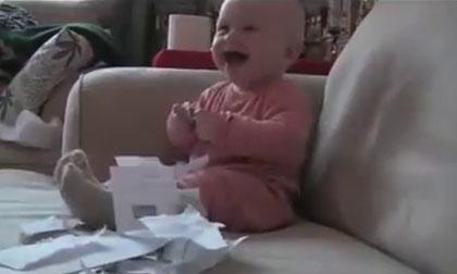 Em bé thích thú với trò chơi xé giấy