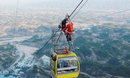 'Ông già Noel' mạo hiểm đu mình trên cáp treo để tặng quà