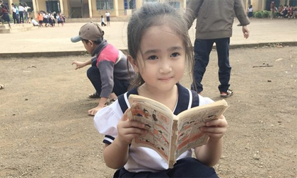 Cô bé tiểu học ở Đăk Lăk gây sốt với bức ảnh ngồi đọc truyện ở sân trường