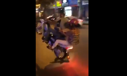 Người đàn ông chở vợ và con trai bốc đầu trên phố