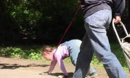 Mẹ xích cổ con như chó dắt đi dạo trong công viên