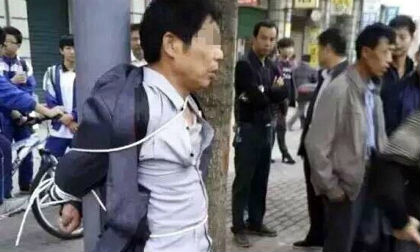 Cha trói kẻ biến thái quấy rối con gái vào cột bên đường