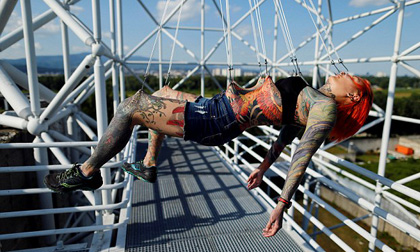 Cô gái dùng móc sắt xuyên vào thịt, treo người lơ lửng trên cao