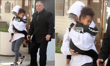 Kim Kardashian trùm kín mặt ôm con trở về nhà