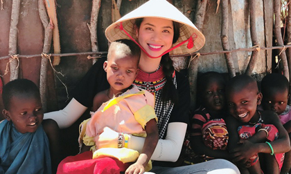 Phạm Hương đeo khăn rằn, thân thiện ẵm bồng trẻ em Kenya
