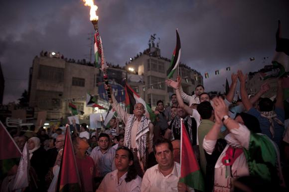 Những người Palestin cầm cờ và đuốc khi  tham dự bài phát biểu của tổng thống Mahmoud Abbas ở Ramallah, Bờ Tây.