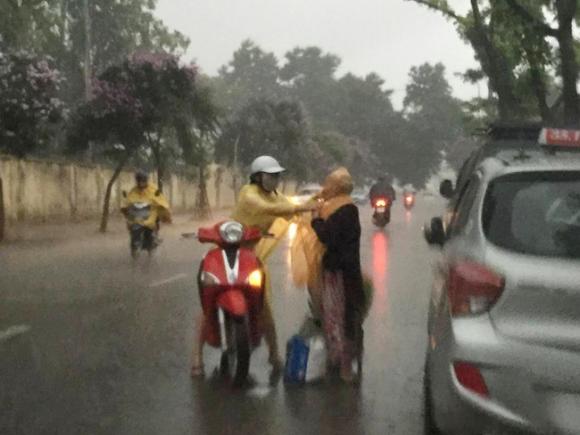 cụ già, cô gái mặc áo mưa cho cụ già, hình ảnh giúp người, giúp đỡ cụ già, đời sống trẻ
